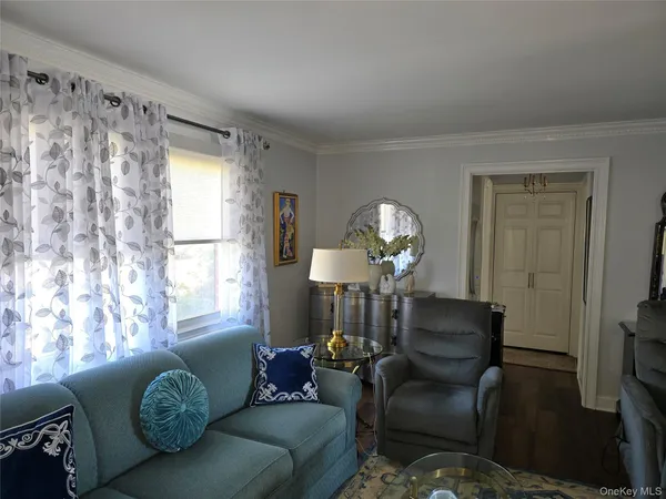 a living room with furniture chandelier and a window