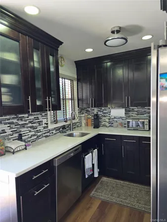 a kitchen with kitchen island granite countertop a sink and cabinets