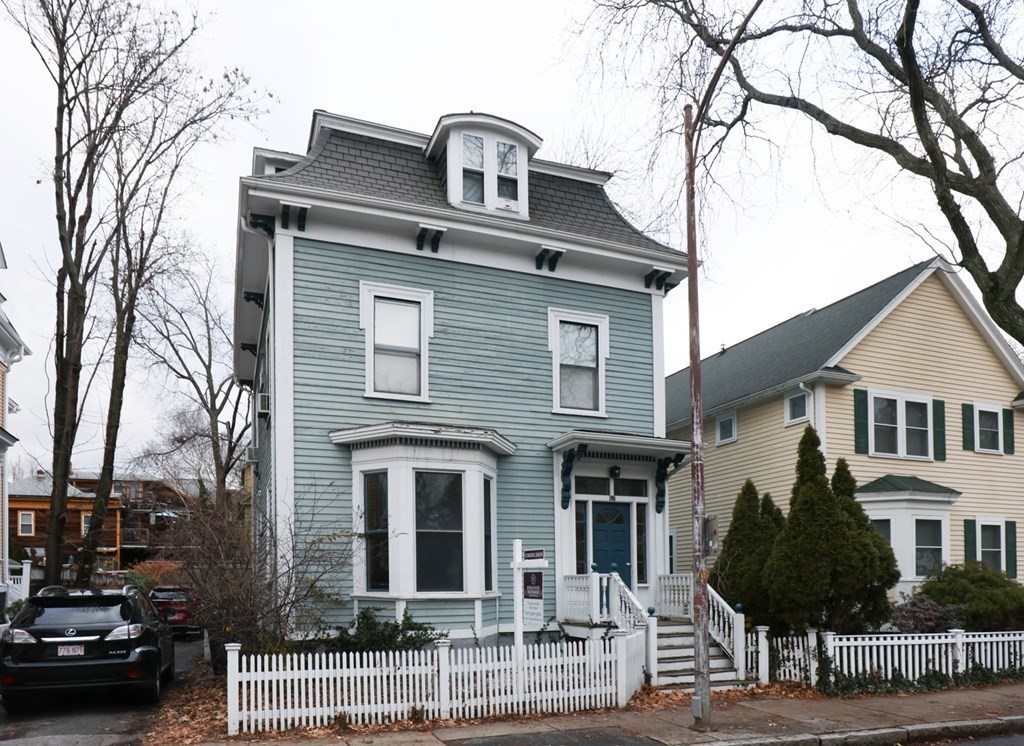 a front view of a house with a tree