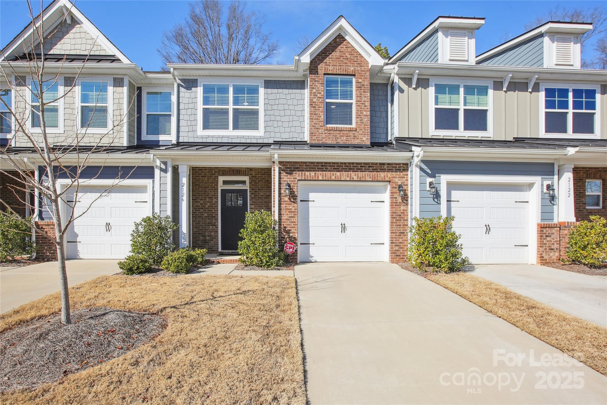 front view of a brick house with a yard
