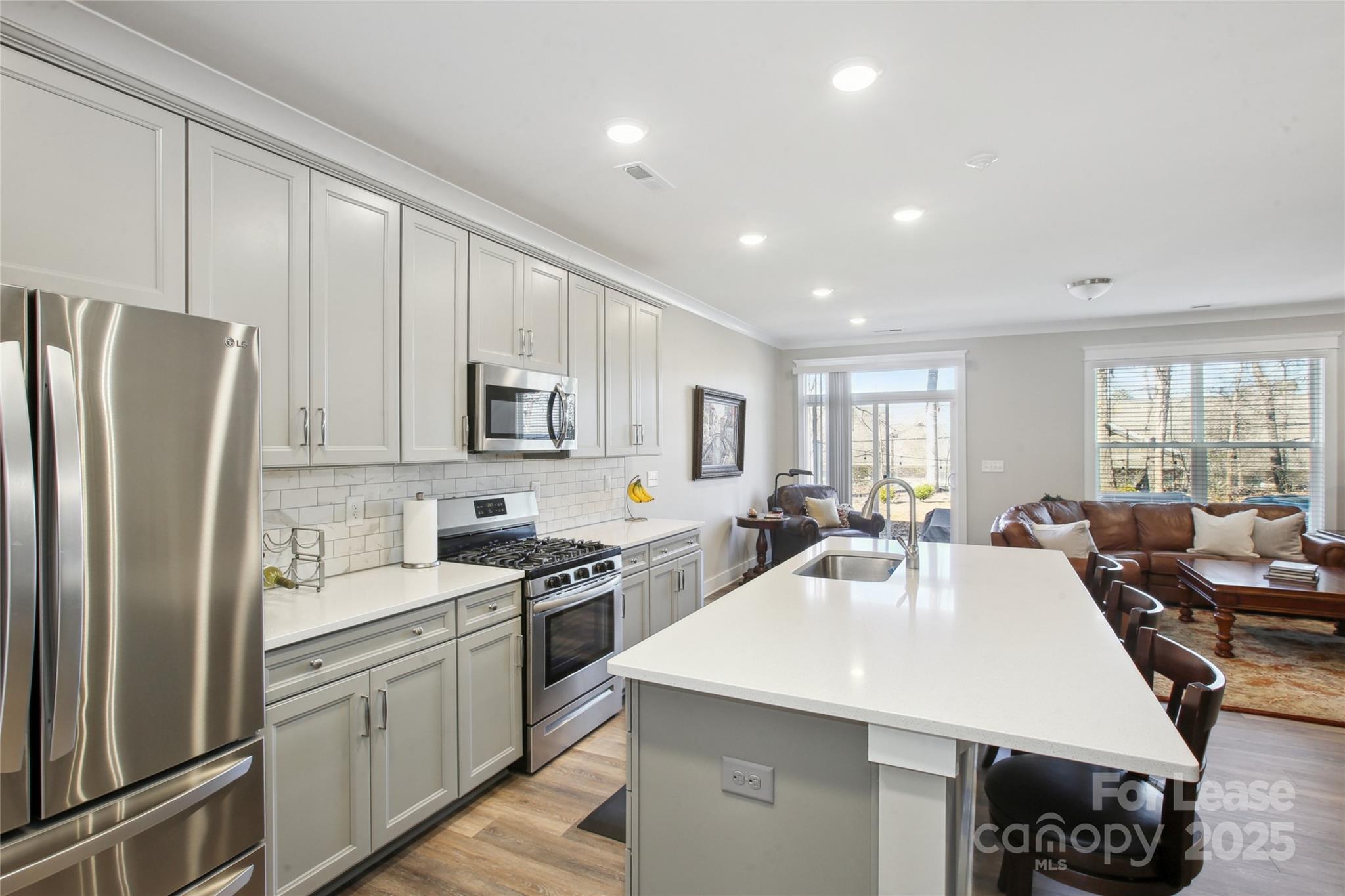 2126 Bexar Trail Matthews, NC 28105 - Photo 6 of 12 a kitchen with stainless steel appliances granite countertop a refrigerator a sink dishwasher a stove and white countertops with wooden floor
