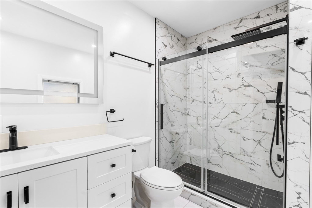 32 Beach Street Malden, MA 02148 - Photo 12 of 31 a bathroom with a shower sink vanity mirror and toilet