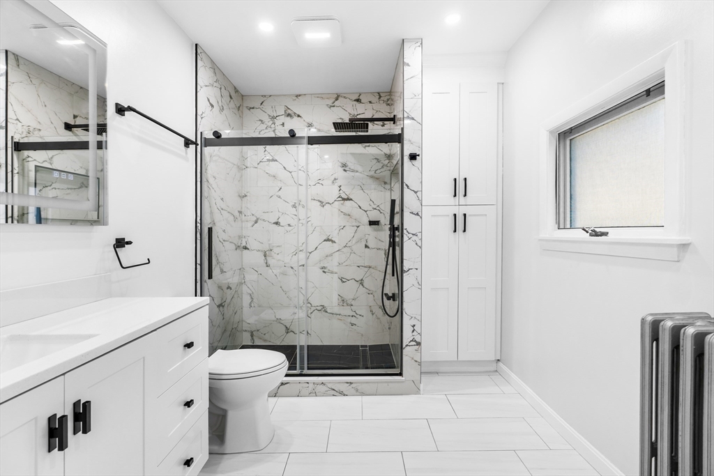 32 Beach Street Malden, MA 02148 - Photo 13 of 31 a bathroom with a shower a sink and a mirror