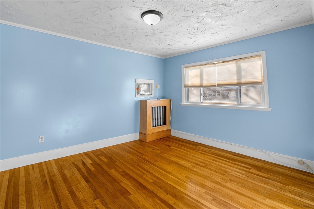 32 Beach Street Malden, MA 02148 - Photo 15 of 31 a view of an empty room with wooden floor and a window