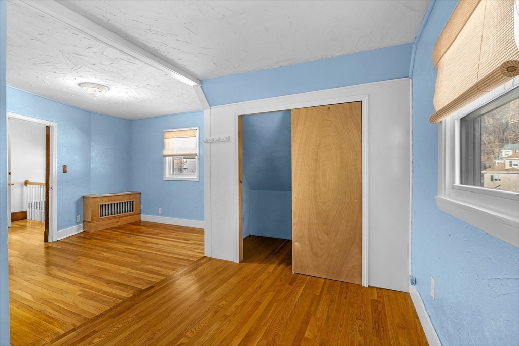 32 Beach Street Malden, MA 02148 - Photo 17 of 31 a bedroom with a bed and wooden floor