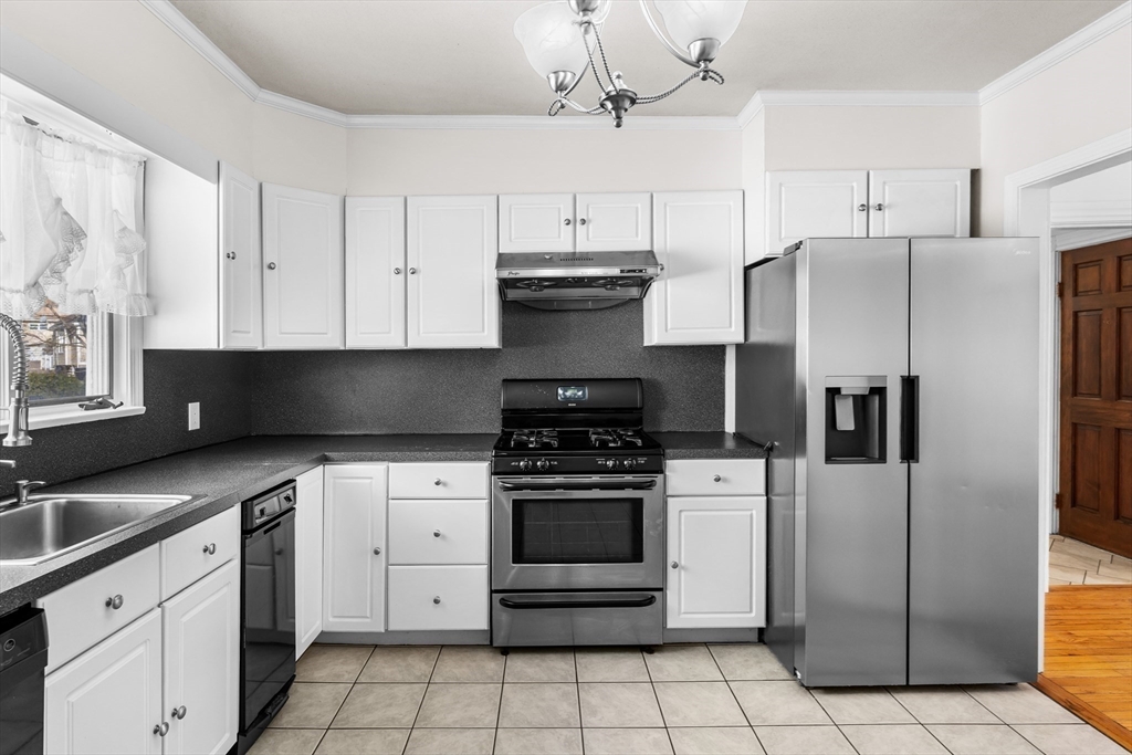 32 Beach Street Malden, MA 02148 - Photo 8 of 31 a kitchen with stainless steel appliances granite countertop a stove a refrigerator and a sink