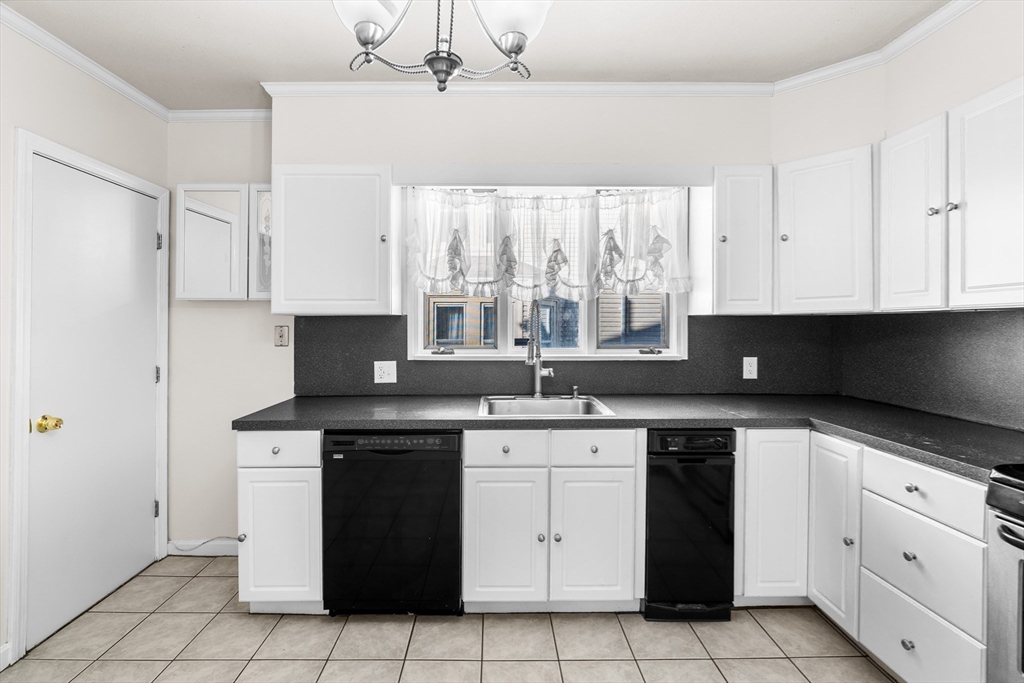 32 Beach Street Malden, MA 02148 - Photo 9 of 31 a kitchen with a stove sink and cabinets