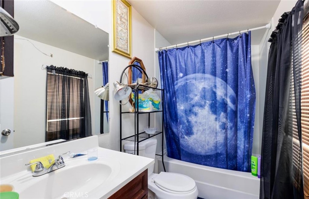 8450 G Avenue Hesperia, CA 92345 - Photo 8 of 10 a bathroom with a sink a toilet and shower curtain