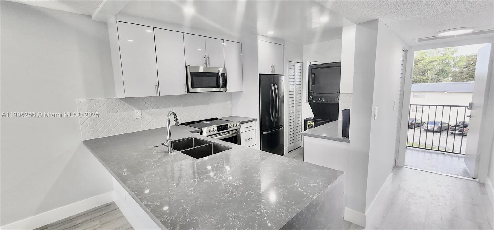 8040 North Colony Circle, Unit 309 Tamarac, FL 33321 - Photo 4 of 15 a kitchen with stainless steel appliances granite countertop a sink a stove and a refrigerator