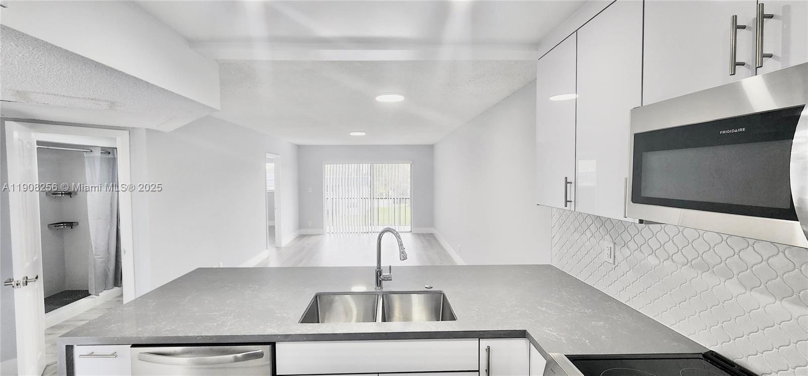 8040 North Colony Circle, Unit 309 Tamarac, FL 33321 - Photo 5 of 15 a kitchen with kitchen island a sink appliances and cabinets