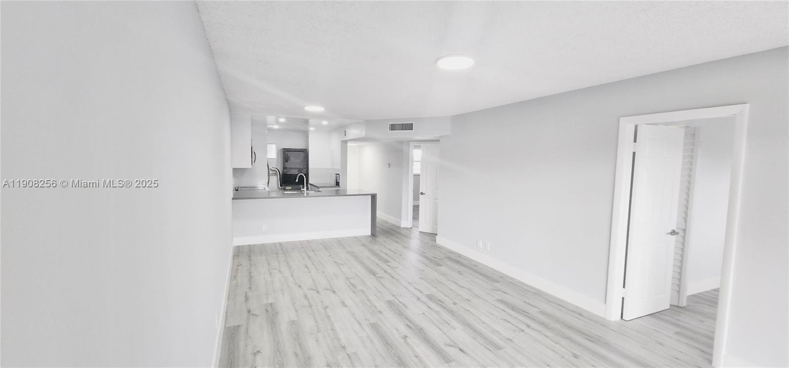 8040 North Colony Circle, Unit 309 Tamarac, FL 33321 - Photo 6 of 15 a view of a kitchen with wooden floor and a refrigerator