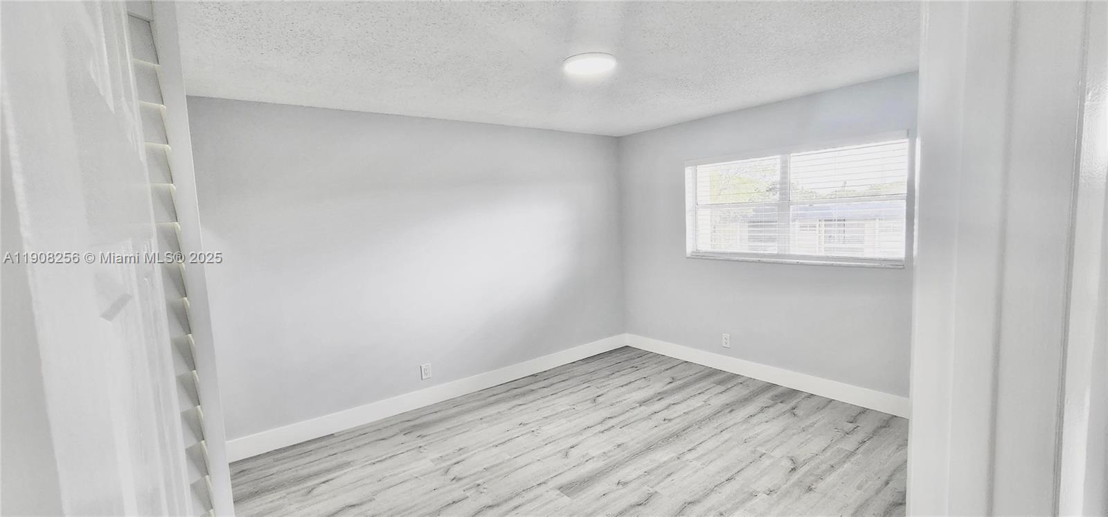 8040 North Colony Circle, Unit 309 Tamarac, FL 33321 - Photo 10 of 15 a view of empty room with wooden floor and fan