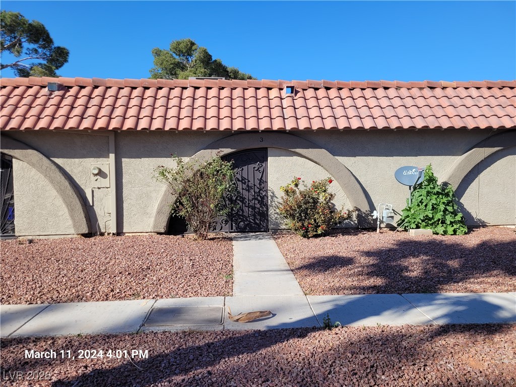 View of home's exterior featuring a tile roof and stucco siding
