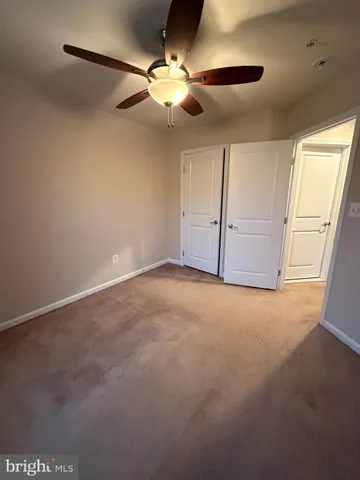 a view of a livingroom with a ceiling fan and window