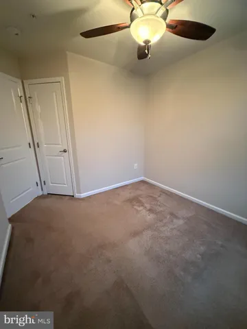 an empty room with a ceiling fan and a window
