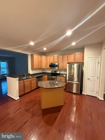 a kitchen with stainless steel appliances wooden floor and large window