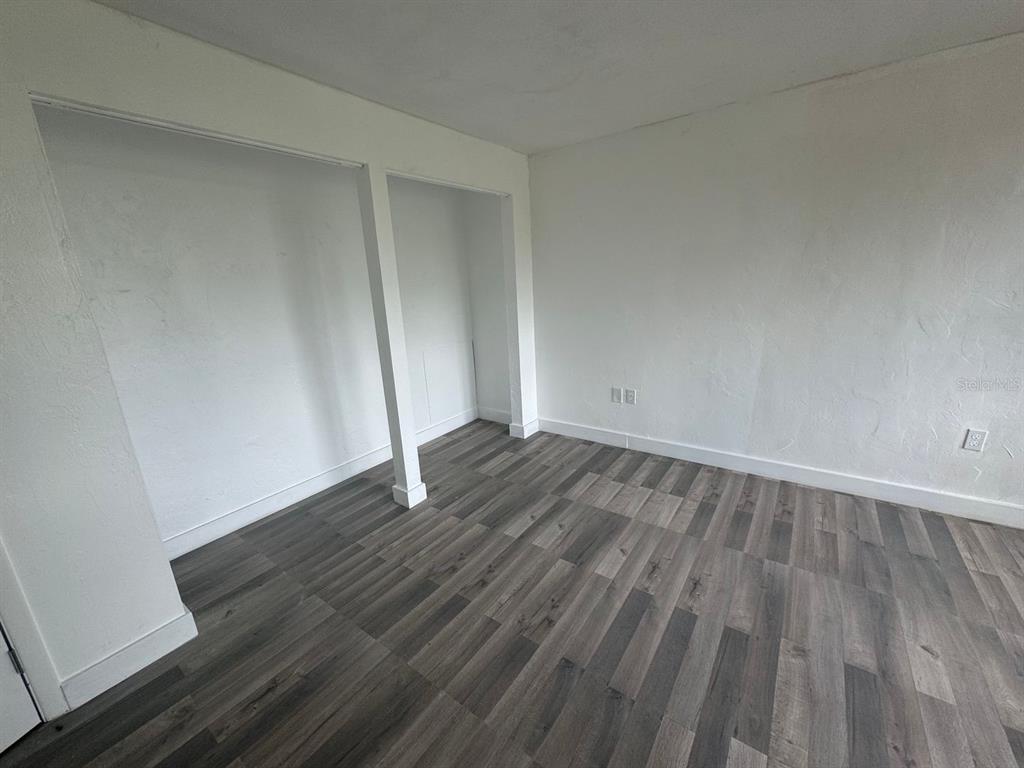 717 Southwest 75th Street, Unit 101 Gainesville, FL 32607 - Photo 11 of 19 an empty room with wooden floor