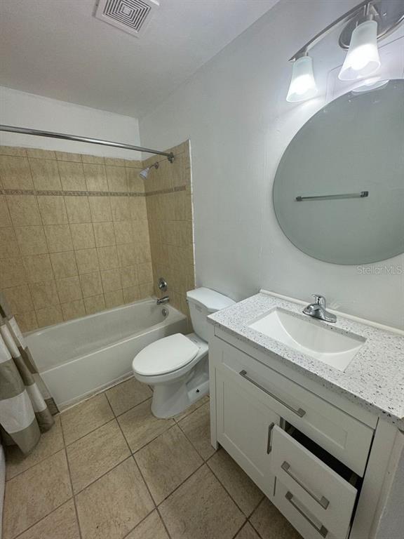 717 Southwest 75th Street, Unit 101 Gainesville, FL 32607 - Photo 15 of 19 a bathroom with a granite countertop sink a toilet a mirror and shower