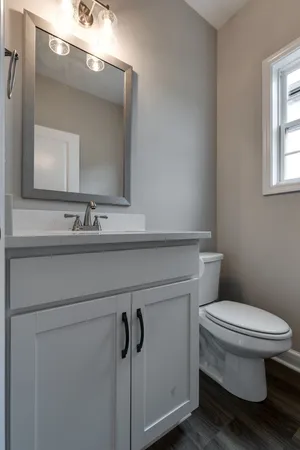 a bathroom with a toilet sink and mirror