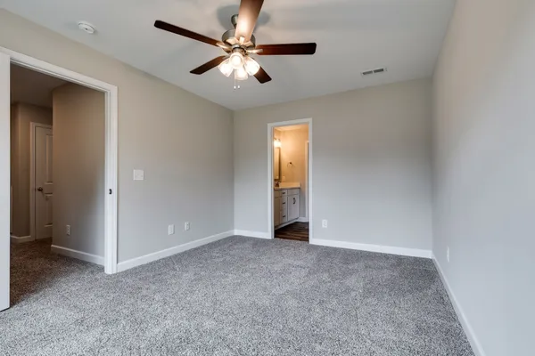 an empty room with closet and a ceiling fan