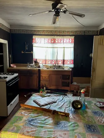 a kitchen with a stove and a wooden floor