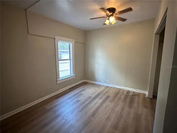a view of room with window ceiling fan and hardwood floor