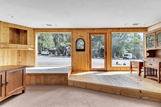 a bedroom with a bed and a large window with balcony view