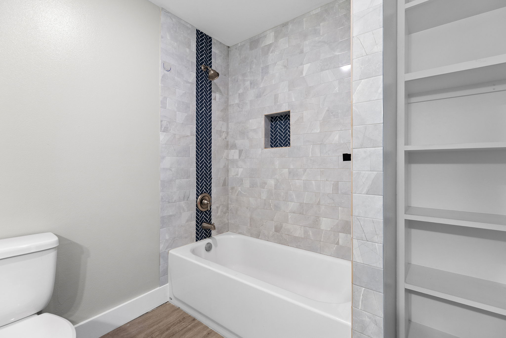 813 Central Avenue Elgin, TX 78621 - Photo 13 of 22 Full bath featuring bathing tub / shower combination and wood finished floors