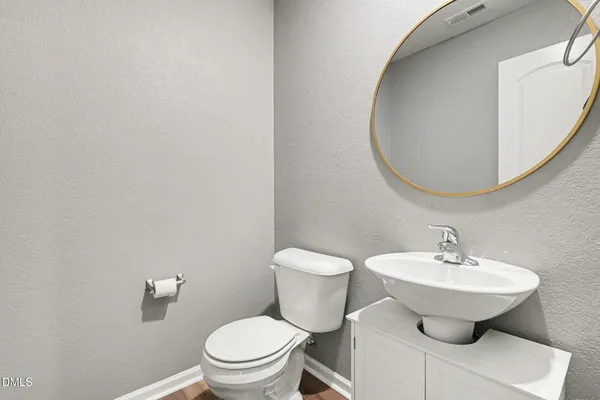 a bathroom with a sink a toilet and mirror