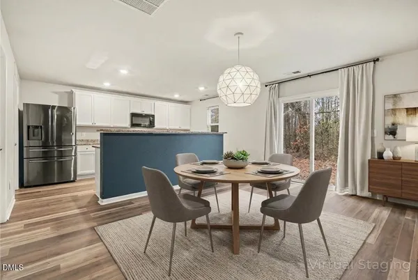 a view of a dining room with furniture a chandelier and wooden floor