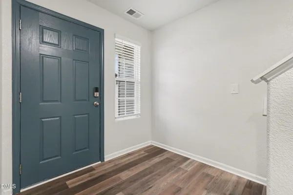 a view of an empty room with closet and a window