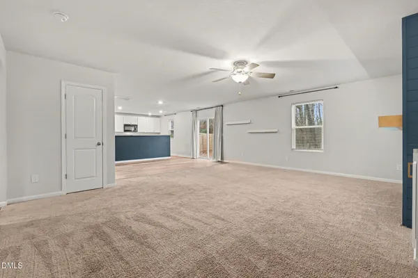 a view of empty room with windows and ceiling fan
