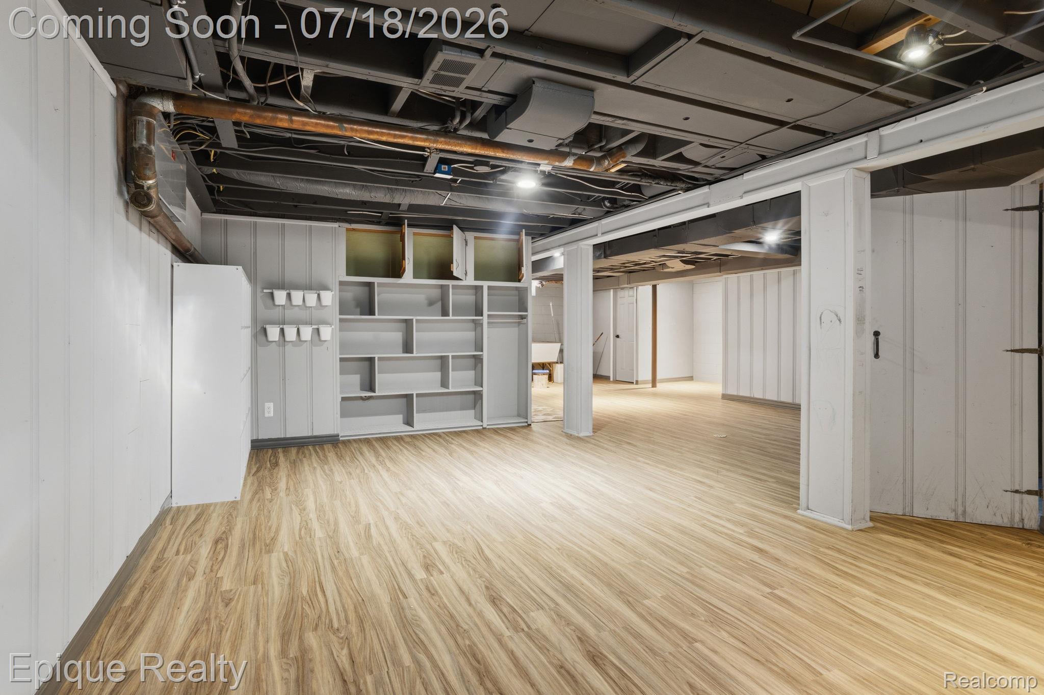 1206 Hawthorne Road Grosse Pointe, MI 48236 - Photo 22 of 28 Finished lower level featuring wood-finish flooring, recessed lighting, built-in shelving, and vertical paneling