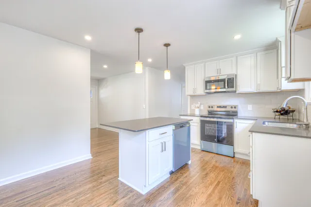 a kitchen with kitchen island a sink stainless steel appliances and cabinets