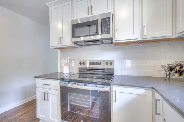 a kitchen with stainless steel appliances granite countertop a sink stove and cabinets
