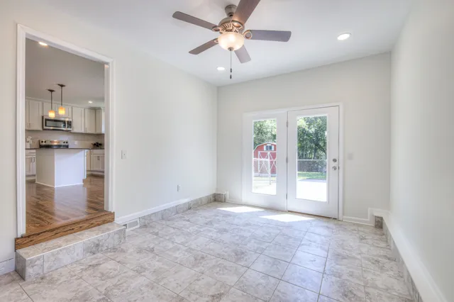 an empty room with windows and fan