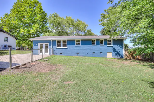 a view of a house with backyard and trees