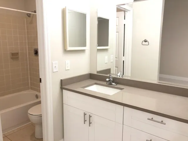 a bathroom with a granite countertop sink toilet and shower