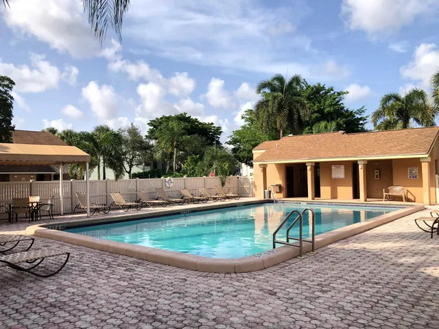 a front view of a house with swimming pool and furniture