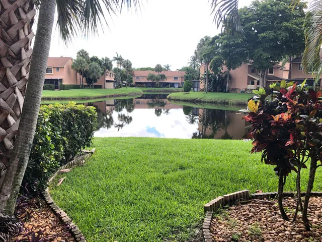 a view of a lake with a yard and potted plants