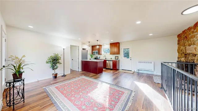 a living room with furniture and potted plants with wooden floor