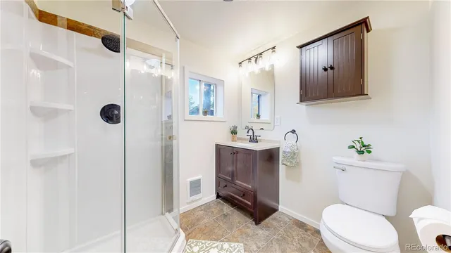 a bathroom with a toilet a sink and shower