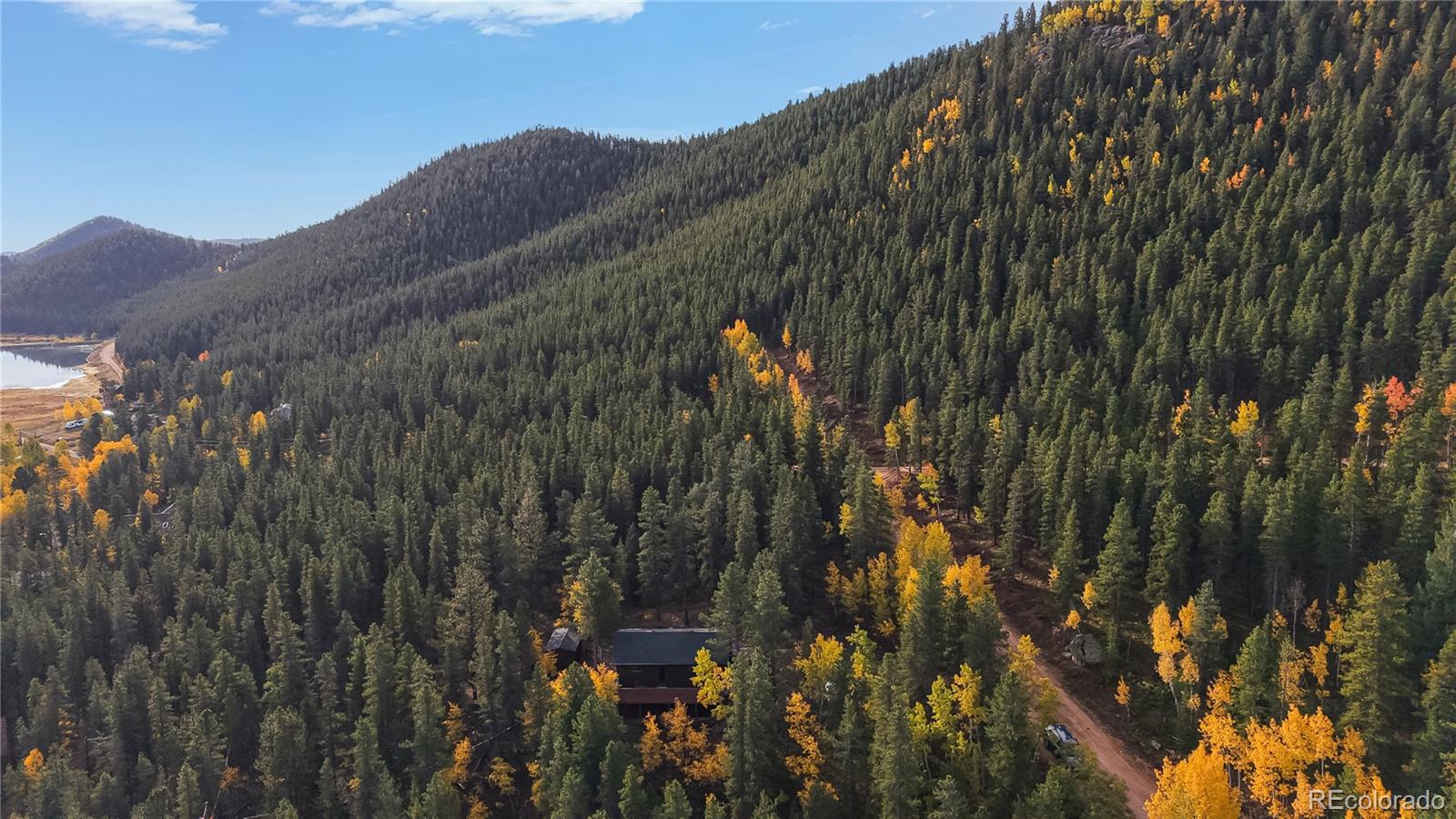 225 Renaud Road Bailey, CO 80421 - Photo 36 of 39 a view of a house with a mountain and trees