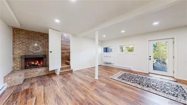 an empty room with wooden floor a fireplace and windows