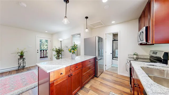 a kitchen with stainless steel appliances granite countertop sink stove and wooden floor