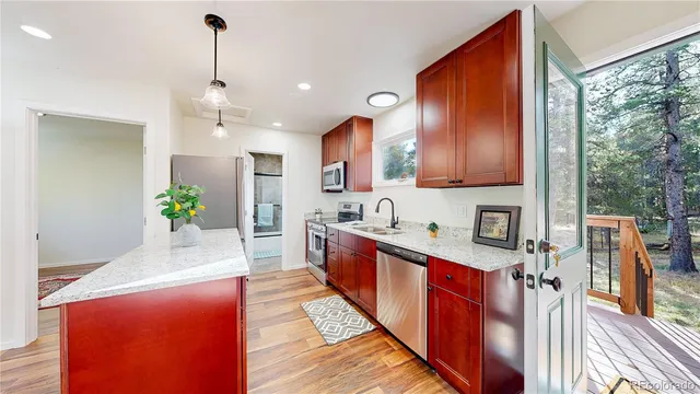 a kitchen with stainless steel appliances granite countertop sink stove refrigerator and cabinets