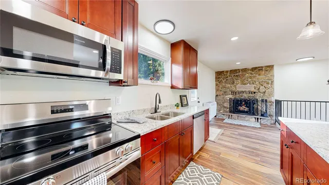 a kitchen with stainless steel appliances kitchen island granite countertop a stove a sink and a microwave
