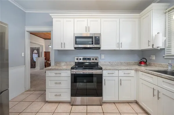 a kitchen with white cabinets and appliances