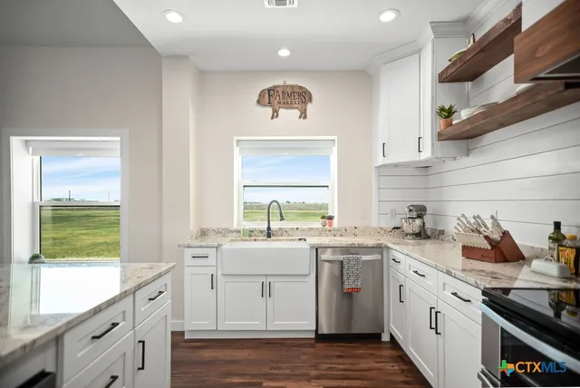 a view of a bathroom with granite countertop a sink and a mirror