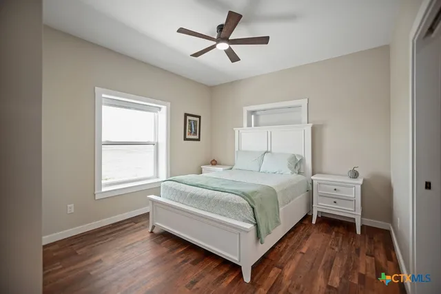 a bedroom with a bed and a chandelier fan